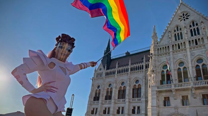 A participant waves a rainbow flag during an LGBT rights demonstration in front of the Hungarian Parliament building in Budapest, Hungary on June 14, 2021