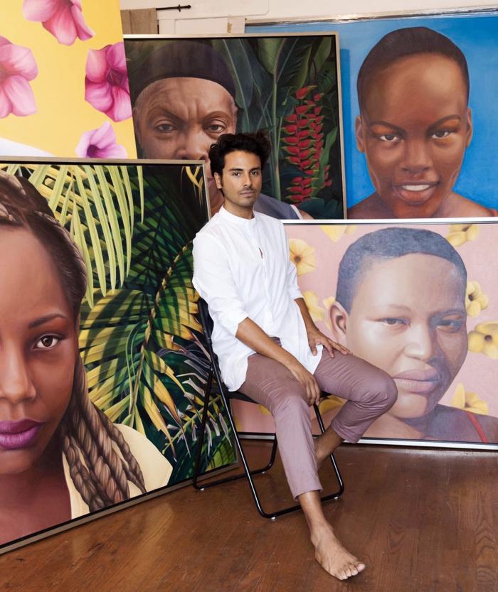 Artist Simon Vargas in front of his portrait series, "Mujeres de Providencia."