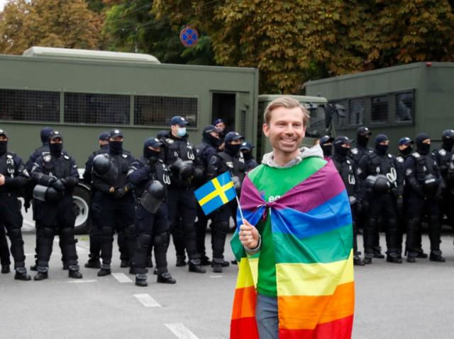 A man draped in a Pride flag in Kyiv, 2021