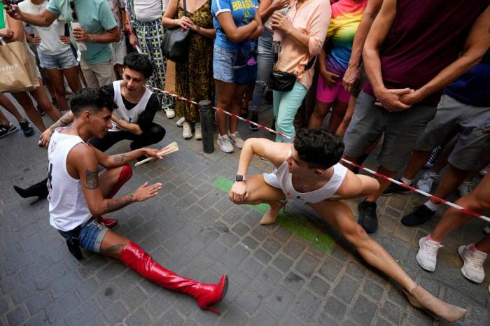 Participants stretch before competing in the Pride Week annual high heels race in the Chueca district, a popular area for the gay community in Madrid, Spain, Thursday, July 4, 2024