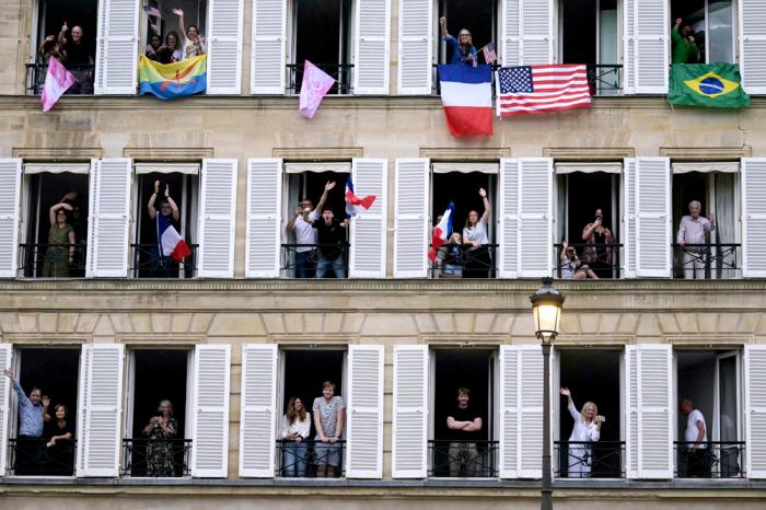 Spectators with various international flags cheering on from their balconies are pictured from the boat of Brazil's delegation sailing on the river Seine during the opening ceremony for the 2024 Summer Olympics in Paris, France, Friday, July 26, 2024