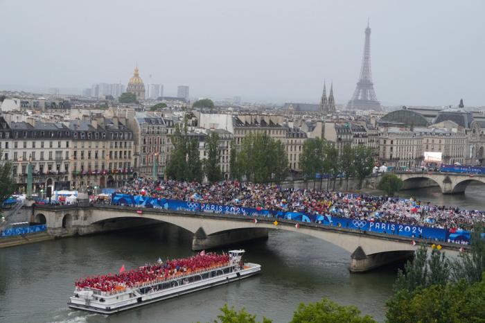 Athletes travel by boat along the Seine River during the opening ceremony of the 2024 Summer Olympics, in Paris, France, Friday, July 26, 2024. (AP Photo/Ricardo Mazalan)