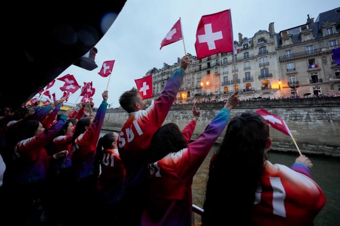 Members of Team Switzerland wave to spectators in Paris, France, during the opening ceremony of the 2024 Summer Olympics, Friday, July 26, 2024. (Martin Meissner/Pool Photo via AP)