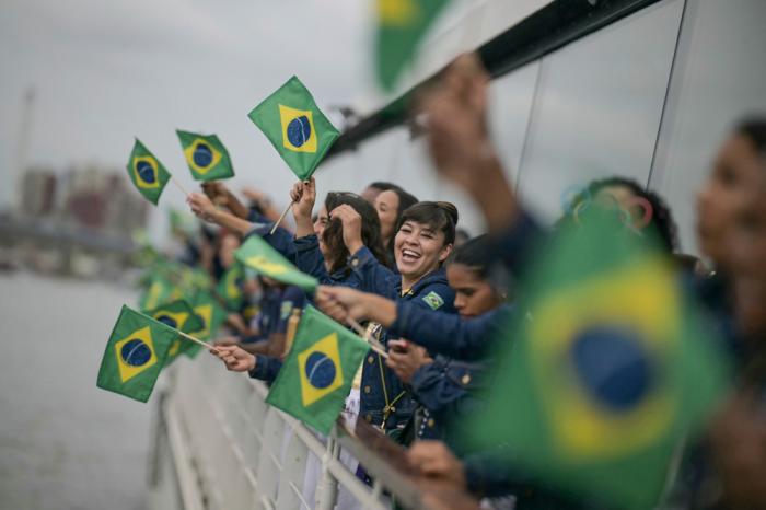 Athletes from Brazil's delegation wave Brazilian flags as they sail in a boat on the river Seine duringt the opening ceremony for the 2024 Summer Olympics in Paris, France, Friday, July 26, 2024. (Carl de Souza/Pool Photo via AP)