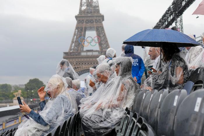 Spectators wait for the start of the opening ceremony of the 2024 Summer Olympics in Paris, France, Friday, July 26, 2024. (AP Photo/Thibault Camus)