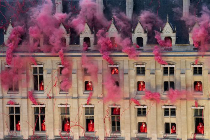 Smoke billows near windows as performers participate during the opening ceremony of the 2024 Summer Olympics, Friday, July 26, 2024, in Paris, France. (AP Photo/Bernat Armangue, Pool)