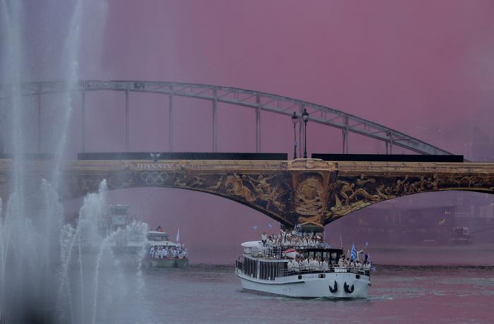 Athletes of Greece aboard a boat as it makes its way along the Seine in Paris, France, during the opening ceremony for the 2024 Summer Olympics, Friday, July 26, 2024. (Ann Wang/Pool Photo via AP)