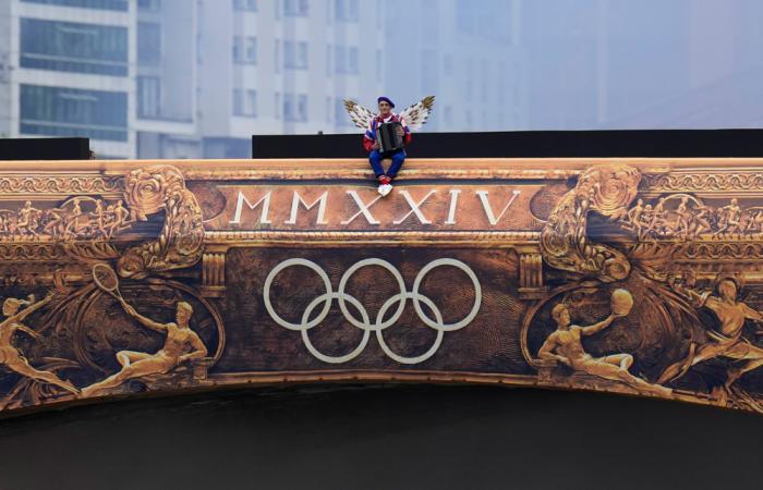 A performer sits on a bridge in Paris, France, during the opening ceremony of the 2024 Summer Olympics, Friday, July 26, 2024. (AP Photo/Kirsty Wigglesworth)