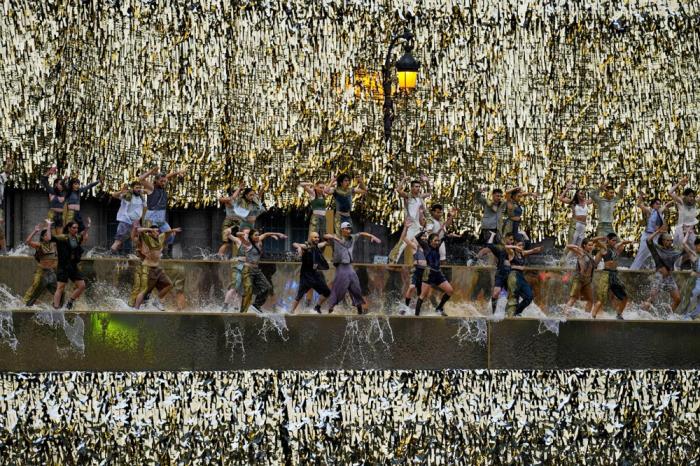 Performers dance along the banks of the Seine River in Paris, France, during the opening ceremony of the 2024 Summer Olympics, Friday, July 26, 2024. (AP Photo/Petros GiannakourisPool)