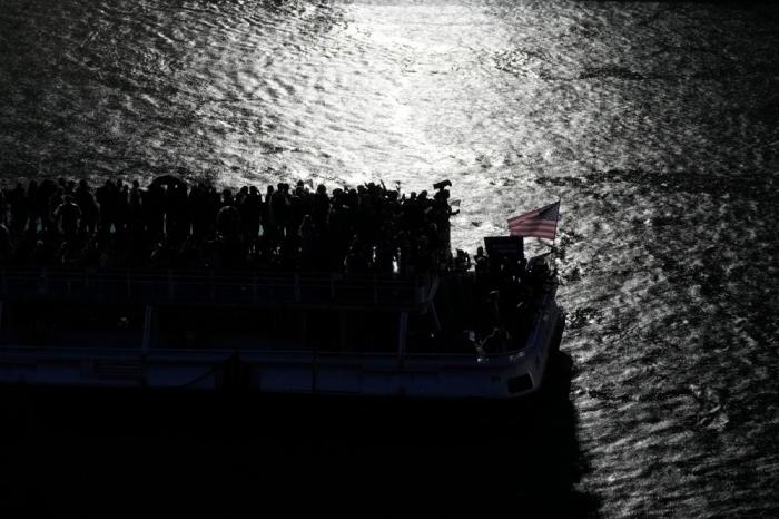 United States athletes on a boat make their way on the Seine River, in Paris, France, during the opening ceremony of the 2024 Summer Olympics, Friday, July 26, 2024. (AP Photo/Alessandra Tarantino)