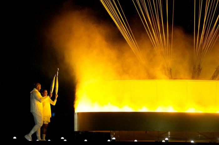 The cauldron is lit by torch bearers Marie-Jose Perec and Teddy Riner in Paris, France, during the opening ceremony of the 2024 Summer Olympics, Friday, July 26, 2024. (AP Photo/Dolores Ochoa)