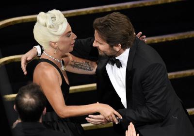 Bradley Cooper, right, congratulates Lady Gaga in the audience after she is announced winner for best original song for "Shallow" from "A Star Is Born" at the Oscars.