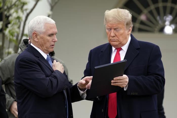 President Donald Trump speaks with Vice President Mike Pence as they arrive for a Fox News Channel virtual town hall, at the White House.
