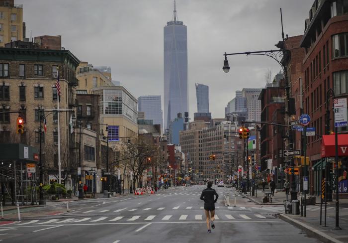 A lone jogger run on a partially empty 7th Avenue in New York City