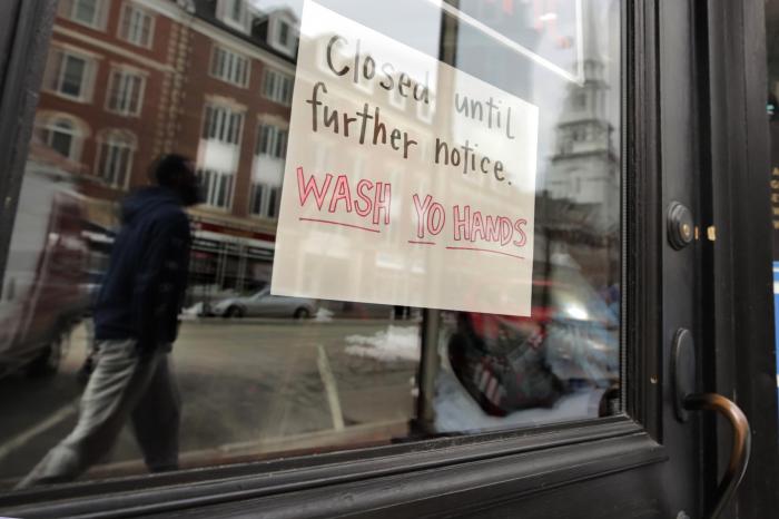 n this March 25, 2020, file photo, a closed sign hangs in the window of a shop in Portsmouth, N.H.