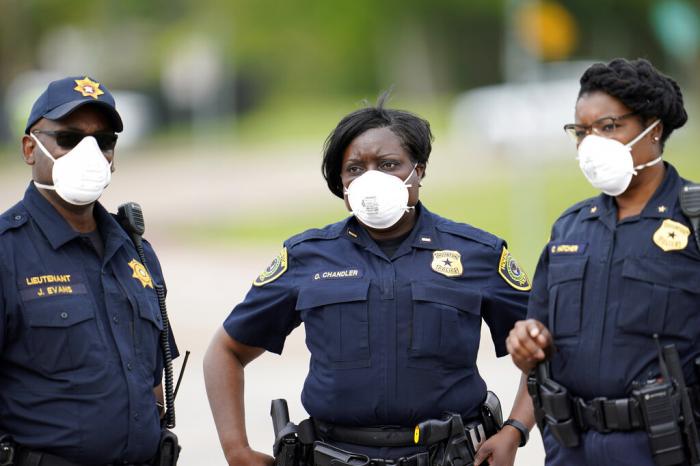 Law enforcement officers wear masks while working at a newly opened free drive through Covid-19 testing site in Houston.