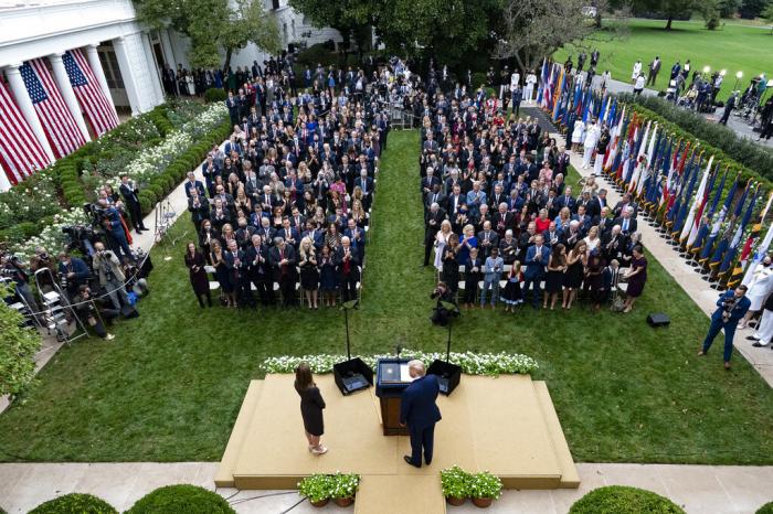 President Donald Trump, center, stands with Judge Amy Coney Barrett as they arrive for a news conference to announce Barrett as his nominee to the Supreme Court, in the Rose Garden at the White House.