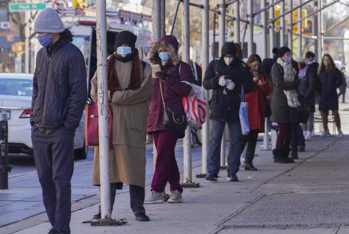 People wait on a line stretching around a block for a clinic offering COVID-19 testing in Brooklyn, New York.