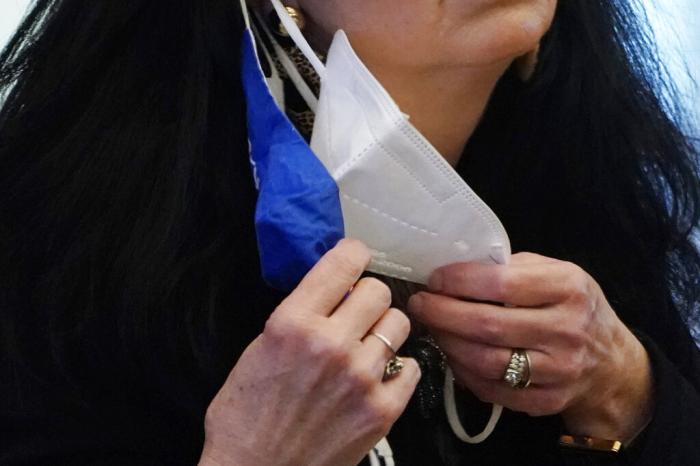 A state legislator adjusts her face masks while asking a question at the Capitol in Jackson, Miss.