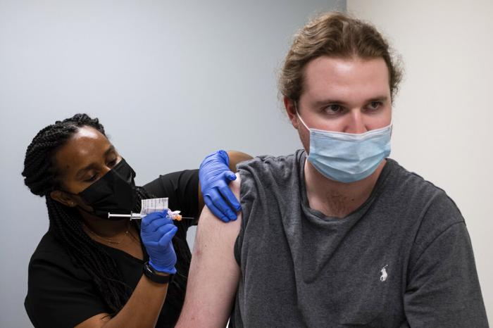 Cole Smith receives a Moderna variant vaccine shot from clinical research nurse Tigisty Girmay at Emory University's Hope Cliniic.