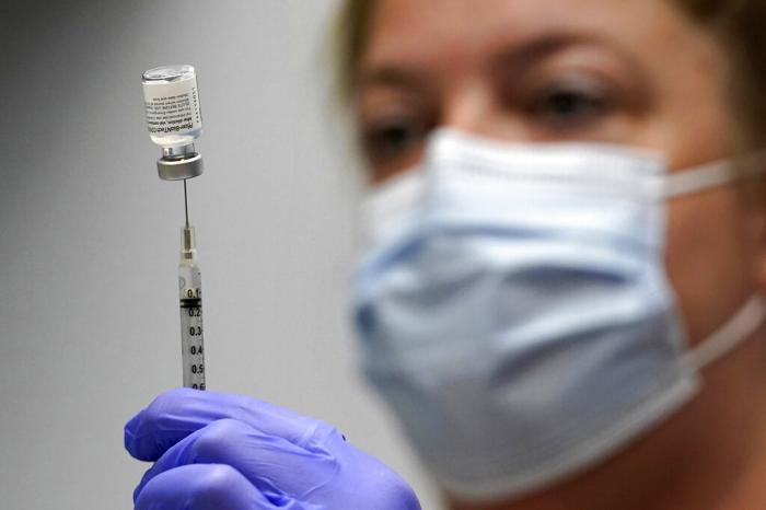  pharmacy technician Hollie Maloney loads a syringe with Pfizer's COVID-19 vaccine at the Portland Expo in Portland, Maine. 