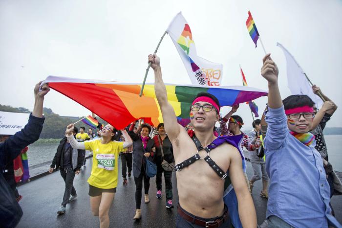 Gay rights activists run with a rainbow flag during the Hangzhou International Marathon in Hangzhou in eastern China's Zhejiang province on Nov. 1, 2015. 
