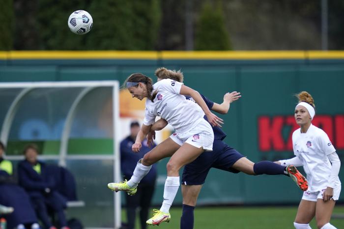 Washington Spirit forward Ashley Hatch, left, heads the ball in front of OL Reign midfielder Quinn in the second half in the semifinals of the NWSL soccer playoffs Sunday, Nov. 14, 2021, in Tacoma, Wash.