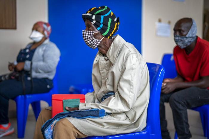 People wait for COVID-19 vaccination at Soweto's Baragwanath hospital.