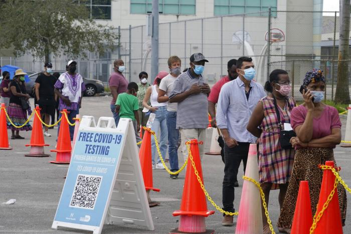 People wait in a long line to get a COVID-19 test, Monday, Jan. 3, 2022, in North Miami, Fla.