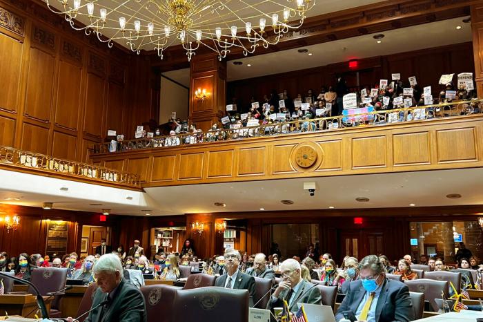 Opponents of a Republican-backed bill that would ban transgender women and girls from participating in school sports that match their gender identity, gather in the Indiana House balcony, Monday, Jan. 24, 2022, during a House Education Committee hearing at the Statehouse. 