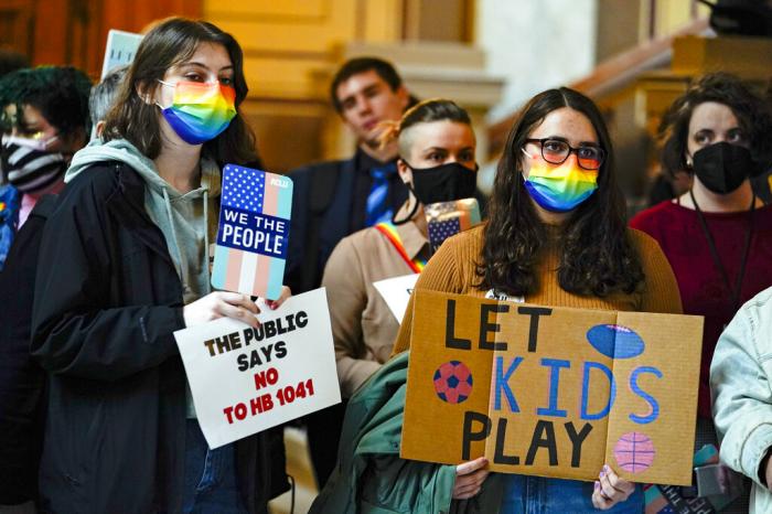 People gather to protest against HB1041, a bill to ban transgender women and girls from participating in school sports that match their gender identity, during a rally at the Statehouse in Indianapolis.