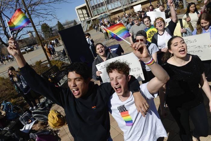Lorenzo Larios, left, and Danny Niemann chant "gay rights" as they join a student protest outside the student center at Brigham Young University in Provo, Utah.