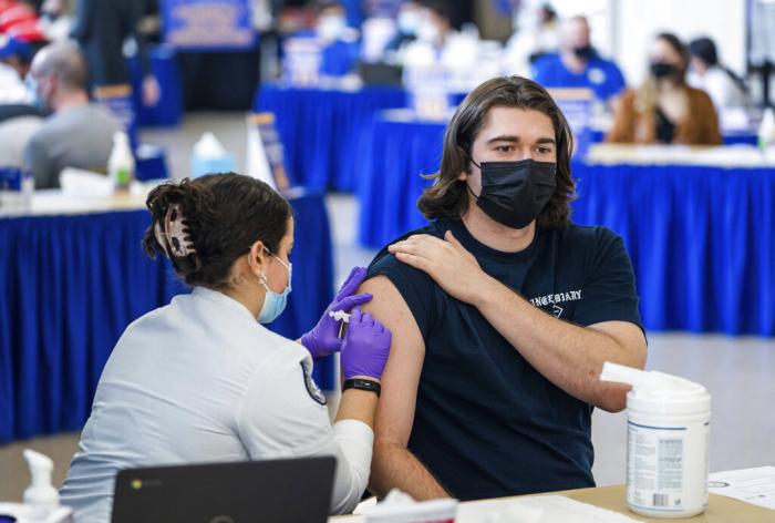 Pitt student Michael Burke, 21, gets a COVID-19 booster shot from nursing student Colette Sayegh, on Wednesday, Jan. 12, 2022.