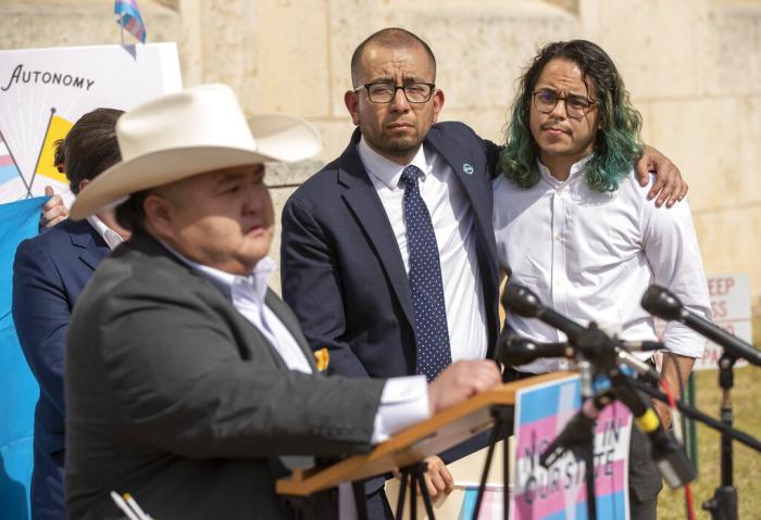 Ricardo Martinez, CEO of Equality Texas, and Adri Perez, right, ACLU of Texas Policy and Advocacy Strategist, listen to Emmett Schelling, Executive Director for the Transgender Education Network of Texas, speak.