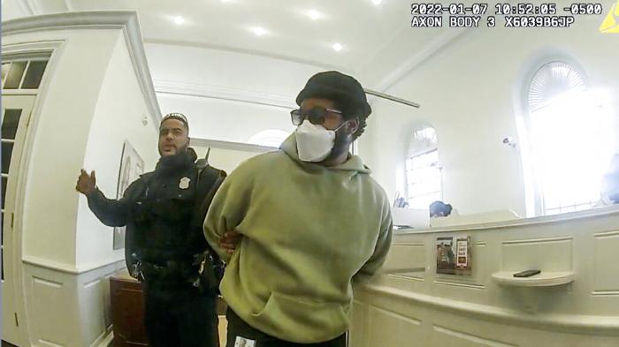 A police officer detains "Black Panther" director Ryan Coogler at a Bank of America branch in Atlanta, in this January 2022.