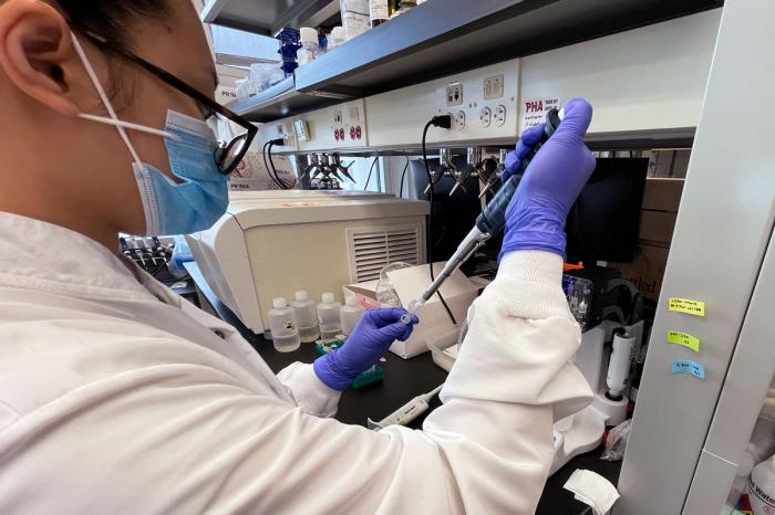 Emily Lu, a student in the environment science graduate program at Ohio State, tries to extract ribonucleic acid (RNA) from wastewater samples to test for fragments of the coronavirus, March 23, 2022 at a school lab in Columbus, Ohio