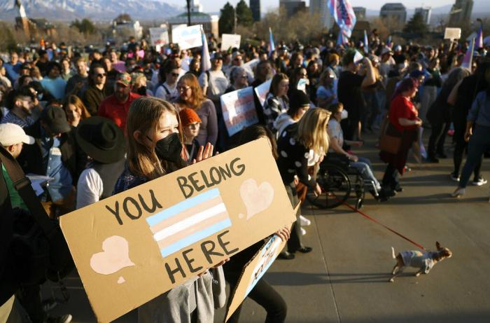 Anika Bateman holds a "You belong here" sign during a rally to support transgender youths outside of the Capitol in Salt Lake City.