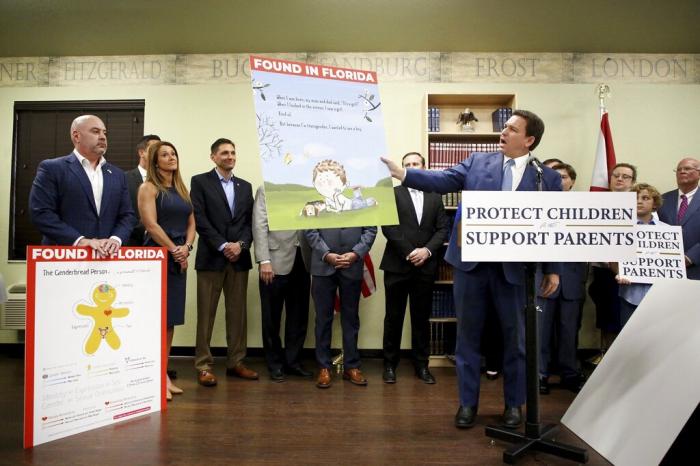 Florida Gov. Ron DeSantis shows an image from the children's book Call Me Max by transgender author Kyle Lukoff moments before signing the Parental Rights in Education bill during a news conference on Monday, March 28, 2022, at Classical Preparatory school in Shady Hills.