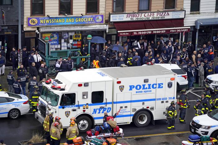Emergency personnel gather at the entrance to a subway stop in the Brooklyn borough of New York, Tuesday, April 12, 2022.