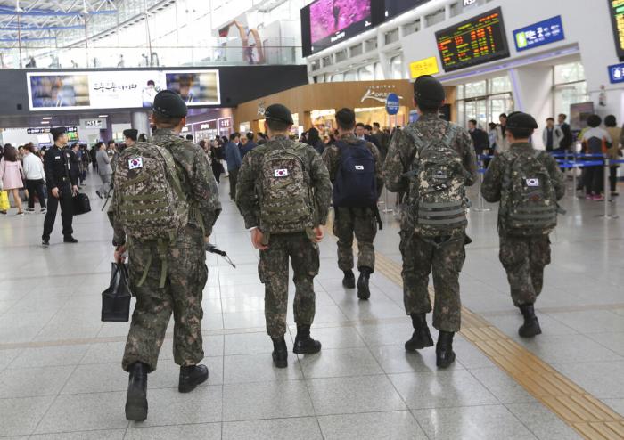 South Korean Army soldiers walk to take their trains at the Seoul Railway Station in Seoul, South Korea.