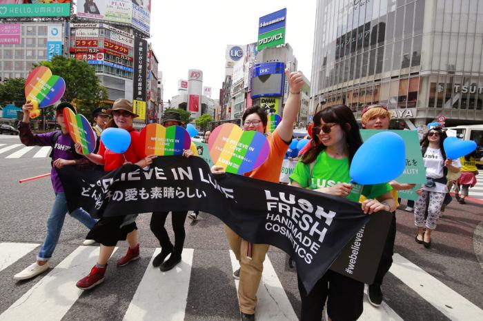 People march with rainbow-colored and heart-shaped posters and a banner during the Tokyo Rainbow Pride parade celebrating the lesbian, gay, bisexual, and transgender and queer or questioning (LGBTQ) community in Tokyo's Shibuya district.