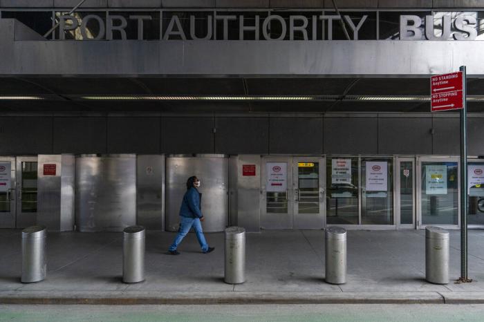 A pedestrian passes the 9th Avenue shuttered doors of the Port Authority Bus Terminal, Friday, Jan. 22, 2021, in New York.