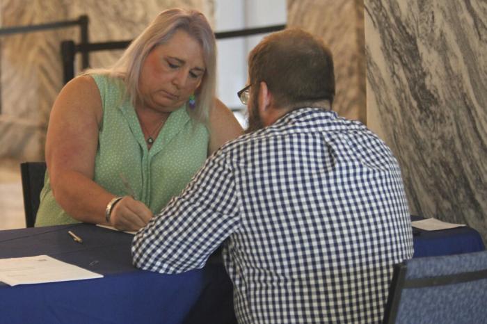 Kansas state Rep. Stephanie Byers, left, D-Wichita, fills out paperwork for Bryan Caskey, state elections director, to withdraw as a candidate for reelection.