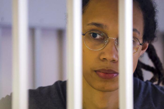 US Basketball player Brittney Griner looks through bars as she listens to the verdict standing in a cage in a courtroom in Khimki, outside Moscow, Russia.