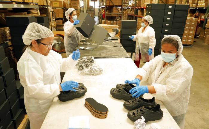 Gabriella Villanueva, clockwise from left, Marina Medina, Gladys Sibrian and Margarita Enriquez assemble Plastic Soul shoe packages at the Doc Johnson factory and corporate offices, Thursday, Aug. 18, 2022, in Los Angeles.
