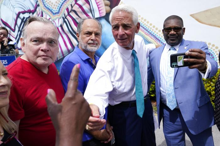 Rep. Charlie Crist, D-Fla., second from right, talks with a supporter outside of the United Teachers of Dade offices, May 31, 2022, in Miami Springs, Fla.