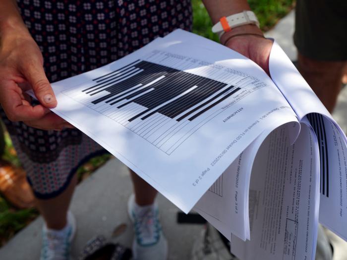 Journalists gather outside the Paul S. Rogers Federal Building and U.S. Courthouse in downtown West Palm Beach, Fla., to read a heavily blackout document released by The Justice Department Friday, Aug. 26, 2022. 