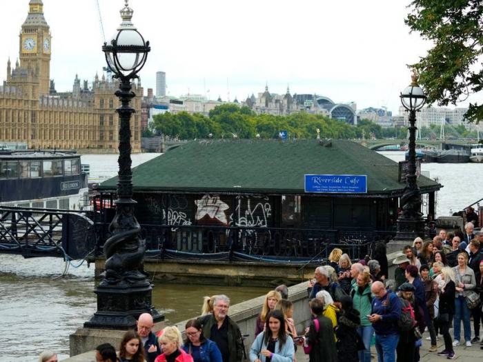 People walk walk past the Riverside Cafe as theyvqueue to pay their respect to the late Queen Elizabeth II during the lying-in state, in Westminster Hall in London, Thursday, Sept. 15, 2022.