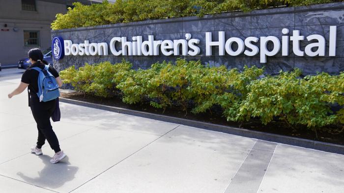 A woman walks past a sign outside the Boston Children's Hospital, Thursday, Aug. 18, 2022, in Boston.