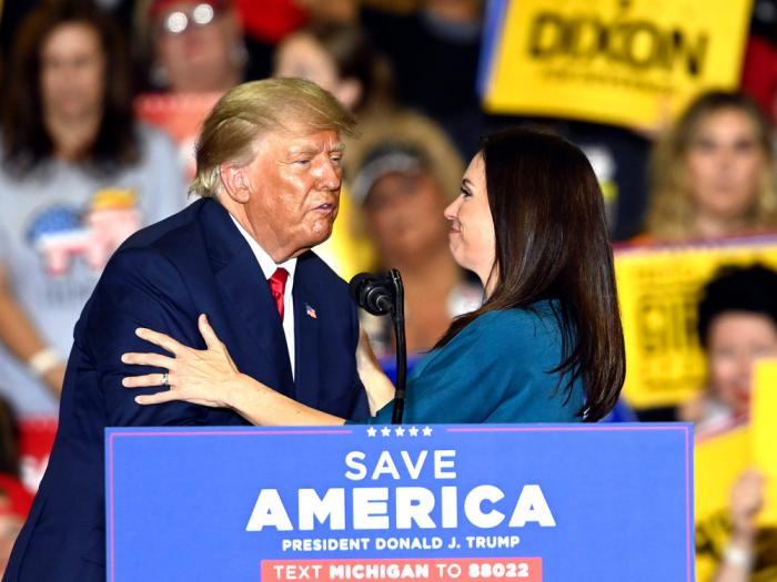 Former President Donald Trump, left, brings Michigan Republican gubernatorial candidate Tudor Dixon onstage, during a rally at the Macomb Community College Sports & Expo Center in Warren, Mich., Saturday, Oct. 1, 2022. (Todd McInturf/Detroit News via AP)